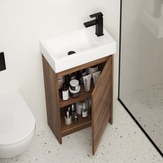 a white toilet sitting next to a sink in a bathroom