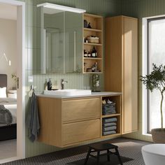 a bathroom with green walls and wooden cabinets