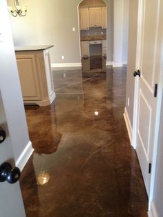 an open door leading to a kitchen and living room in a house with marble floors