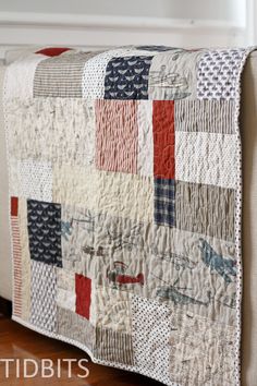 a quilted bed with red, white and blue squares on it