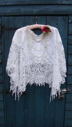 "This is a stunning poncho fashioned from a vintage white cotton Battenburg lace tablecloth. I have tried to preserve much of this beauty by creating a small  V or square neckline, to keep the lace, depending on how which way you want to wear this... This has a wonderful deep lace border. I have added some vintage white lace mats at the front and back to hide some marks. There are breaks in the lace but I have left these as this is part of who they are; part of history. I have shown pics with a V neckline and square neckline....  A simple slip over style ,freshly laundered and ready to wear.... This should fit MOST sizes BUT please see measurements below... Laid flat measured from side to side is around 51\" so all around this will be 102\" approx LENGTH from top of shoulder to hem is 24\" Vintage White Shawl Scarf, White Lace Shawl With Lace Trim, Bohemian Lace Shawl With Lace Work, White Lace Bohemian Shawl, Bohemian Cream Lace Shawl, Bohemian Lace Shawl In Cream, Bohemian Lace Shawl In Cream Color, Bohemian Lace For Wedding, Poncho Fashion