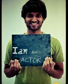 a man holding up a sign that says i am an actor