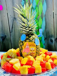 a pineapple and some cut up fruit on a plate