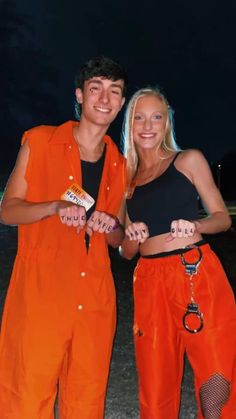 two people in orange jumpsuits posing for a photo together with one person wearing an orange vest