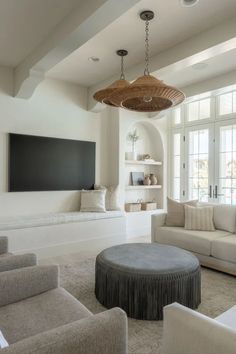 a living room filled with furniture and a flat screen tv mounted to the side of a wall