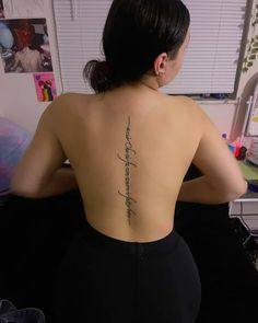 the back of a woman's body with writing on her upper and lower back