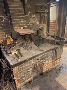 an old brick oven in the middle of a room filled with firewood and other items