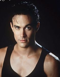 a man in black tank top looking at the camera