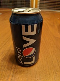 a can of love soda sitting on top of a wooden table