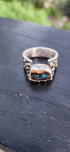 Cool, chunky and gender neutral ring with and bright offset Australian boulder opal. The opal is ethically sourced from Australia. This ring is handmade using sterling silver and has lots of 9ct gold balls snuggled around the setting. Size R.5 Australian Boulder Opal, Funky Jewelry, Opal Ring, Boulder Opal, Opal Rings, Rings Statement, Sterling Silber, Jewelry Inspiration, Statement Rings