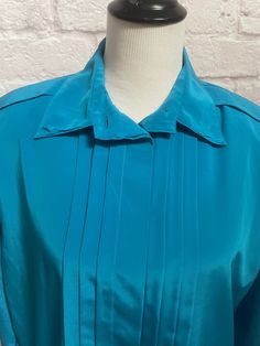 "Vintage Turquoise Blouse, Pleated Front Blouse, Long Sleeve Blouse, Summer Spring Blouse, Secretary Blouse, Best Gift for Her Vintage Blouse by Josephine Women Turquoise Blouse Material is Polyester Pleated front with hidden buttons Pleats on shoulders and gathers at shoulder (gives it a puffed sleeve look) Shoulder pads which can be easily removed with a snip of a thread if desired Fabric covered buttons at cuffs Straight Hem Size 38 Measurements  Chest 46\" Waist 46\" Length 29\" Condition is Turquoise Long Sleeve Blouse, Vintage Green Silk Top, Green Silk Collared Blouse, Blue Collar Blouse For Daywear, Blue Vintage Blouse With Collar, Vintage Blue Daywear Blouse, Vintage Blue Blouse For Daywear, Blue Silk Blouse For Daywear, Secretary Blouse