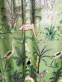 a green curtain with animals and birds on it