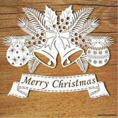 paper cut out of christmas decorations on top of a wooden surface with the words merry christmas