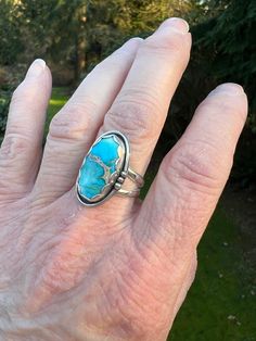 Swimmingly beautiful Sea Sediment Jasper stone that brings to mind Caribbean blue seas!  This stone is so pretty - the blue has hints of white and a lovely gold matrix crosses the center. Set in fine and sterling silver, the stone is framed with a pretty scalloped bezel and a simple shadow box with wire and bead border.   Definitely one of our favorites!  The ring has a nice weight and a very comfortable split shank.  Ring is US Sized 6.75.  The face of the setting is approximately 1/2 inch wide by 1 inch length.   We are a small family business.  All of our jewelry is handmade by us with fine and sterling silver and beautiful stones.  We source the majority of our turquoise cabochons from small business lapidary artists located in the United States. Find us on Instagram: @RimmerCreations Blue Rings With Large Stone For Healing, Unique Blue Moonstone Ring, Blue Moonstone Healing Ring, Unique Blue Cabochon Moonstone Ring, Unique Blue Moonstone Cabochon Ring, Bohemian Blue Ring With Large Stone, Unique Blue Moonstone Ring With Natural Stones, Blue Untreated Southwestern Rings, Turquoise Gemstone Moonstone Ring