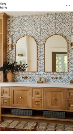 a bathroom with blue and white tiles on the wall, two mirrors above the sink