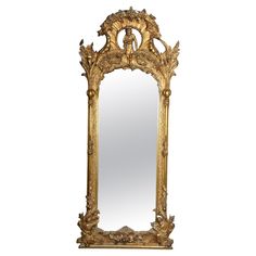 an ornate gold framed mirror with birds on it's sides and leaves around the edges