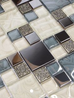 a close up view of a glass and metal mosaic tile design on a wall or floor