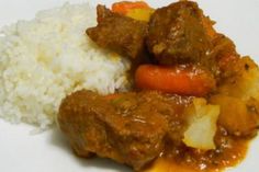 a white plate topped with meat and rice