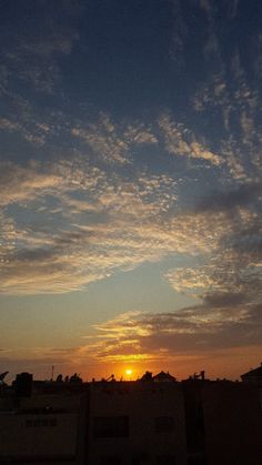 the sun is setting behind some clouds in the sky