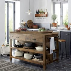 a kitchen filled with lots of pots and pans on top of a wooden table