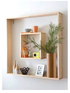 a wooden shelf with some plants and pictures on it