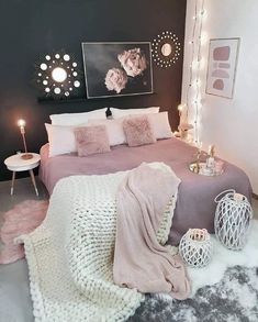 a pink and black bedroom with white fur on the floor, lights in the background