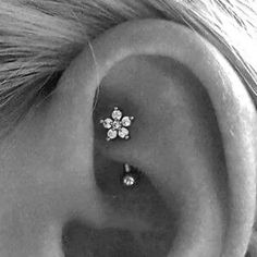 a woman's ear with three small flowers on it