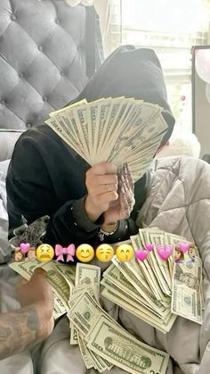 a person sitting on a bed with lots of money in front of their face and eyes