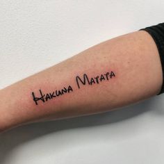 a woman's arm with the word hakuna matata tattooed on it