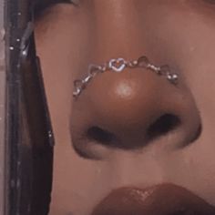 a woman's nose with a heart shaped nose chain