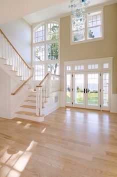 an empty living room with stairs and windows