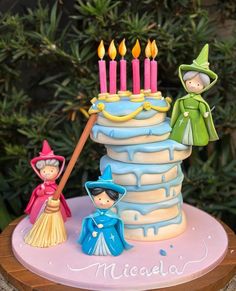 a birthday cake with candles and figurines on it