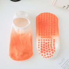 two pairs of orange and white socks sitting next to each other on top of a table