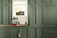 a kitchen with green cabinets and a window