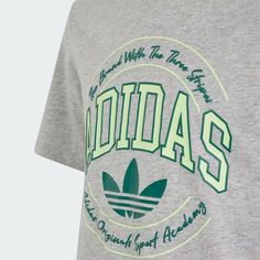 T-SHIRT VRCT DA BAMBINO T-SHIRT CASUAL IN PURO COTONE CHE CELEBRA LA TUA PASSIONE PER ADIDAS. Mostra la tua passione per adidas con questa T-shirt junior. Ispirata a uno stile college old-school, presenta un'audace grafica che sottolinea la tua connessione al brand 3-Stripes. Abbinala a un paio di pantaloni casual o di jeans per un look nostalgico. In ogni caso, la struttura in cotone e la vestibilità regolare la rendono perfetta da indossare tutti i giorni. Vestibilità regolare Girocollo a cost Casual Green T-shirt With Adidas Logo, Sporty Athletic Heather T-shirt With Text Print, Green Letter Print T-shirt For Sportswear, Green Letter Print Sportswear T-shirt, Green Athleisure Tops With Three Stripes Branding, Casual Green Adidas Logo Top, Athletic Heather Sporty T-shirt With Text Print, Gray Sportswear T-shirt With Graphic Print, Casual Green Top With Adidas Logo