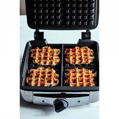 four waffles are being cooked in a griddle on top of a counter