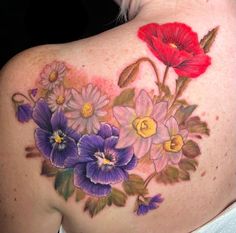 a woman's back with flowers painted on her shoulder and the upper part of her body