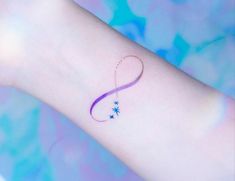 a small tattoo on the wrist of a woman's left arm, with stars