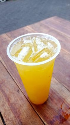 a yellow drink sitting on top of a wooden table