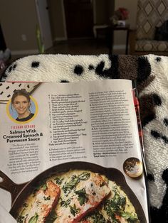 an open magazine about salmon with spinach and parmesan sauce