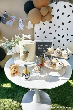 a table topped with cupcakes and cakes on top of a white cake stand