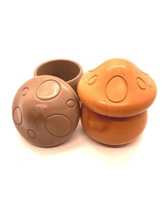 three clay pots sitting next to each other on a white surface