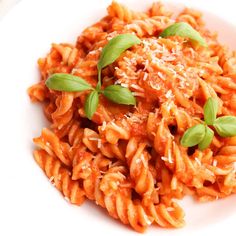 a white plate topped with pasta covered in sauce