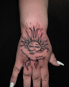 a hand with a sun and lightning tattoo on it