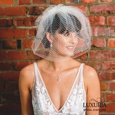 a woman with a veil on her head wearing a wedding dress and bridal necklace