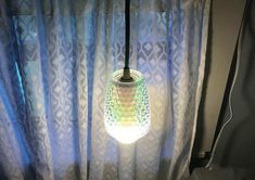 a lamp that is on top of a window sill in front of a curtain