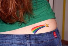 a woman with a rainbow tattoo on her stomach