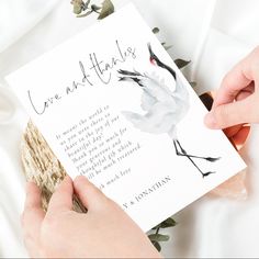 two hands holding a card that reads love and thanks with a crane on it, while another hand holds a piece of wood