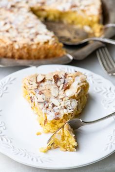 a piece of pie on a plate with a fork next to it and another slice in the background