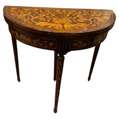 an ornately decorated wooden table with gold and black paint on the top, against a white background